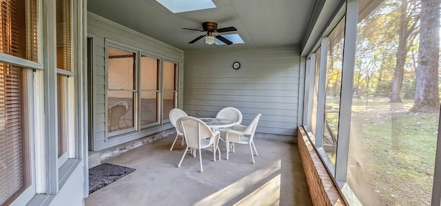 unfurnished sunroom with a skylight and ceiling fan