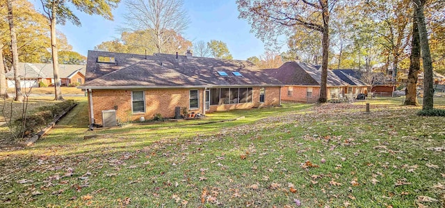 rear view of property featuring a yard and central AC unit