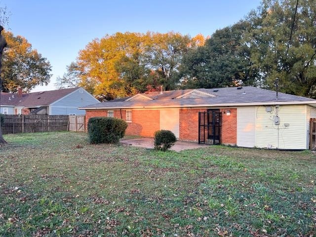 back of house with a yard and a patio area