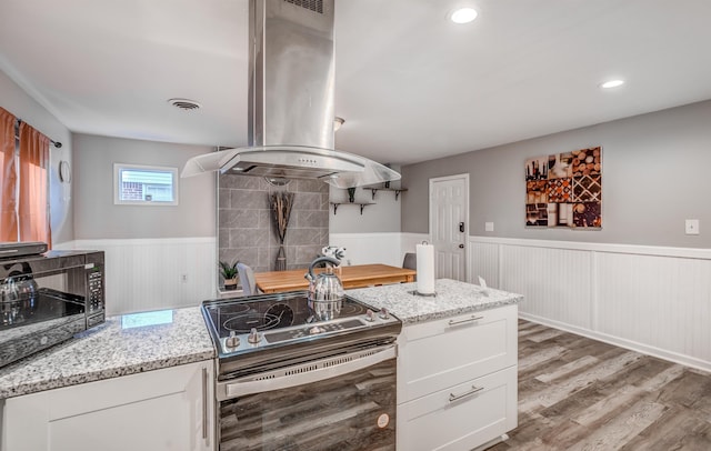 4493 Quince Rd, Memphis, TN 38117 - kitchen featuring electric stove, island exhaust hood, wainscoting, light wood-style flooring, and white cabinets