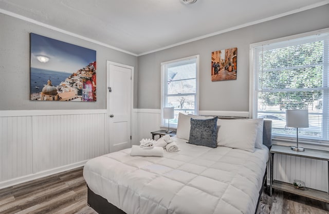 bedroom with hardwood / wood-style floors, radiator heating unit, and ornamental molding