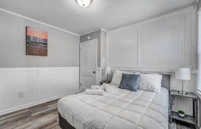 bedroom with wood-type flooring and ornamental molding