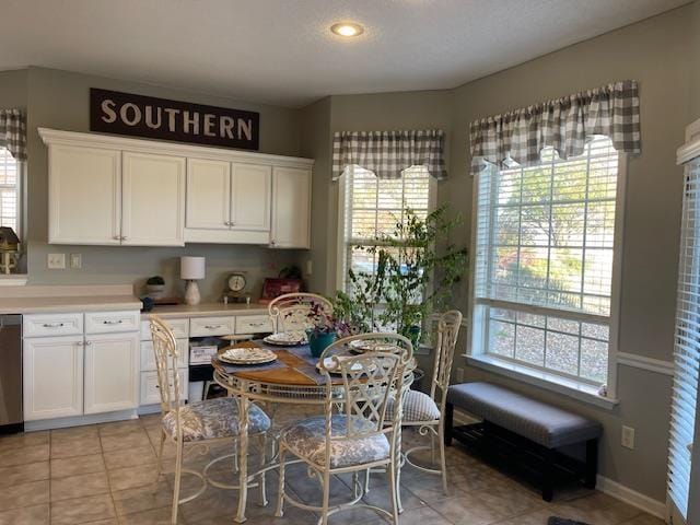 kitchen with white cabinets, dishwasher, and light tile patterned flooring