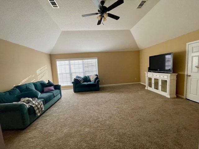 carpeted living room with a textured ceiling, ceiling fan, and vaulted ceiling