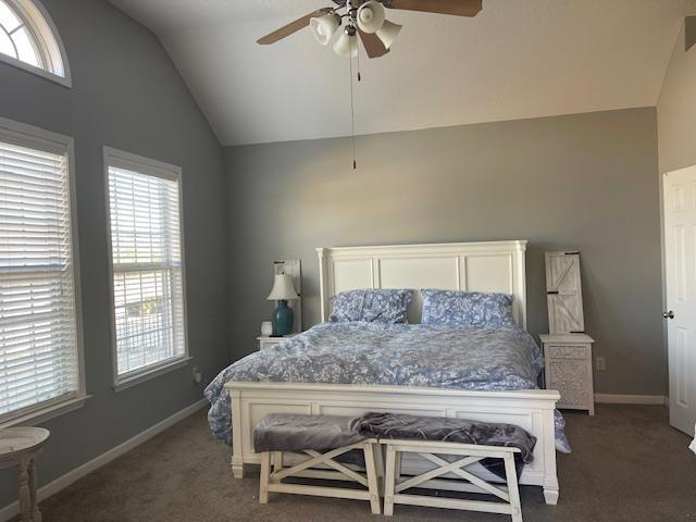 carpeted bedroom featuring vaulted ceiling, multiple windows, and ceiling fan