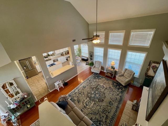 living room featuring ceiling fan, high vaulted ceiling, and hardwood / wood-style flooring