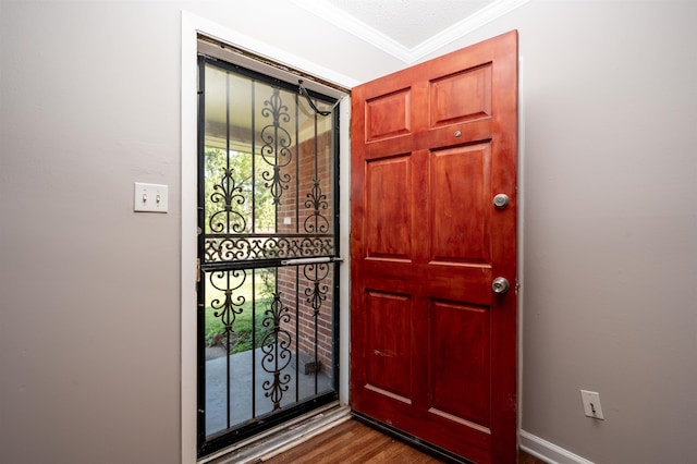 entrance foyer with ornamental molding and dark wood-type flooring