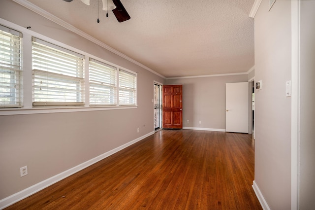 empty room with a textured ceiling, dark hardwood / wood-style floors, ceiling fan, and ornamental molding