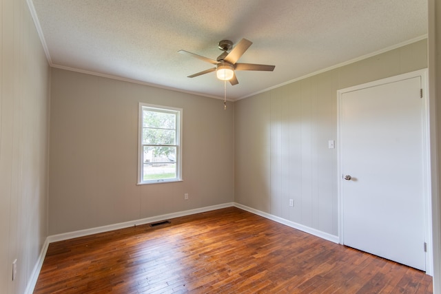 empty room with a textured ceiling, hardwood / wood-style flooring, and ornamental molding