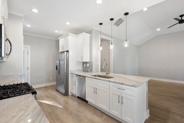 kitchen featuring light stone countertops, sink, pendant lighting, white cabinets, and appliances with stainless steel finishes