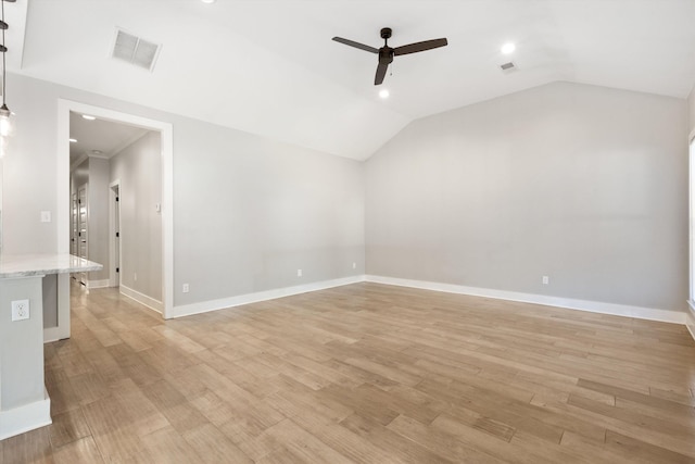 spare room featuring ceiling fan, lofted ceiling, and light hardwood / wood-style flooring