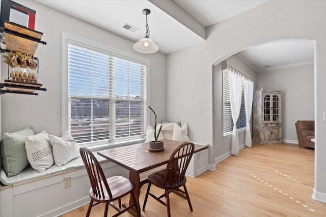 dining area with light wood-type flooring and crown molding