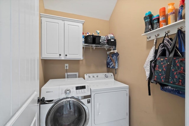 laundry room featuring washer and clothes dryer and cabinets