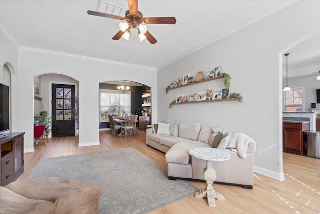 living room featuring crown molding, light hardwood / wood-style floors, and ceiling fan with notable chandelier