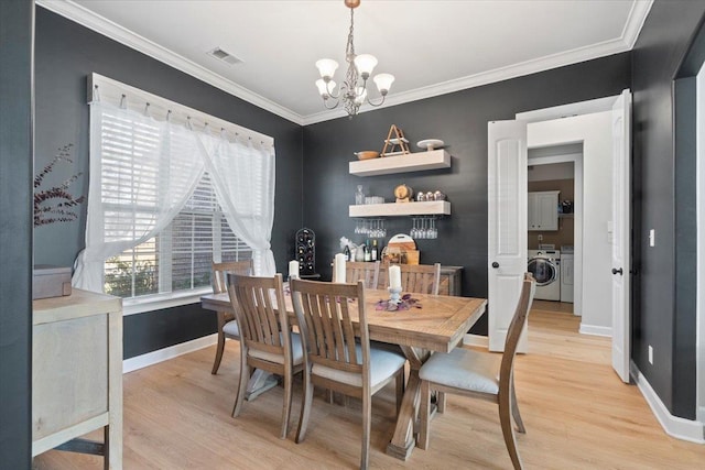 dining area featuring a notable chandelier, light hardwood / wood-style floors, washing machine and dryer, and crown molding