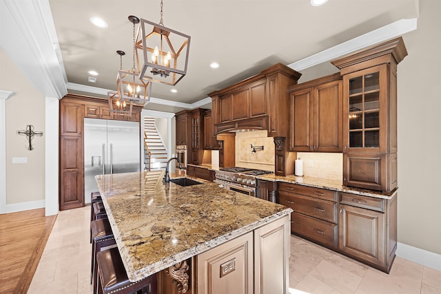 kitchen featuring a large island, high end appliances, sink, and a breakfast bar