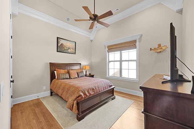 bedroom featuring light hardwood / wood-style floors, vaulted ceiling, ceiling fan, and crown molding