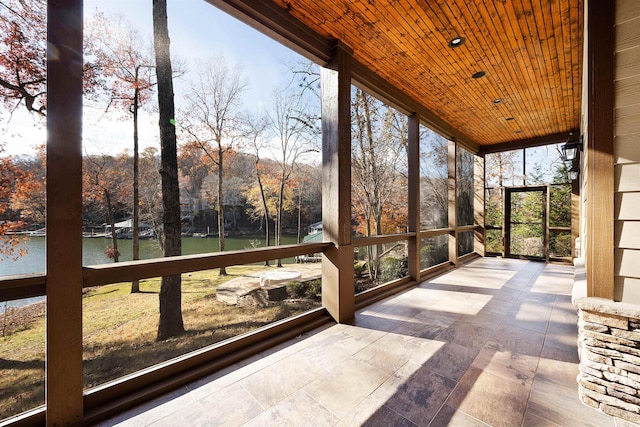 unfurnished sunroom with a water view and wood ceiling