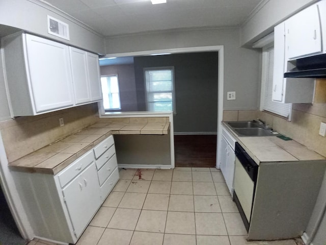 kitchen with ornamental molding, sink, dishwasher, white cabinetry, and tile counters