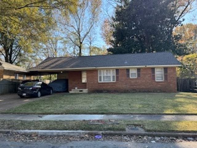 1675 Haywood Ave, Memphis, TN 38127 - view of front facade featuring an attached carport, driveway, and brick siding