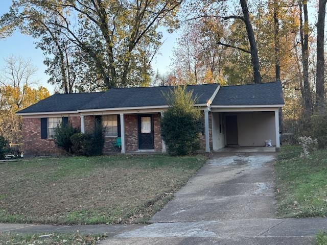 ranch-style home with a front lawn and a carport