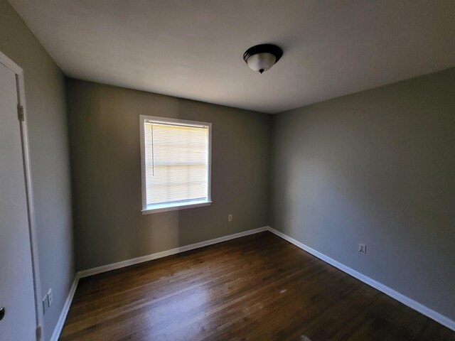 empty room with dark wood-type flooring