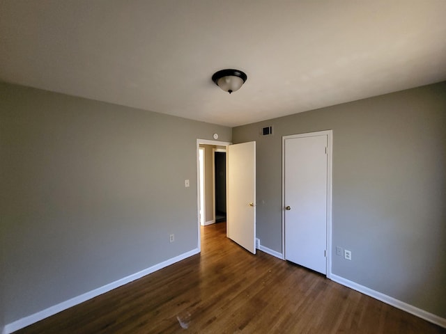 unfurnished bedroom featuring dark hardwood / wood-style flooring