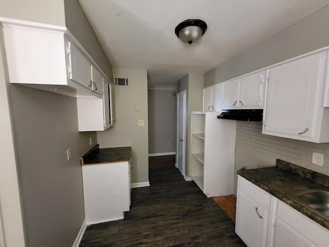 kitchen with white cabinets, sink, dark hardwood / wood-style flooring, and backsplash