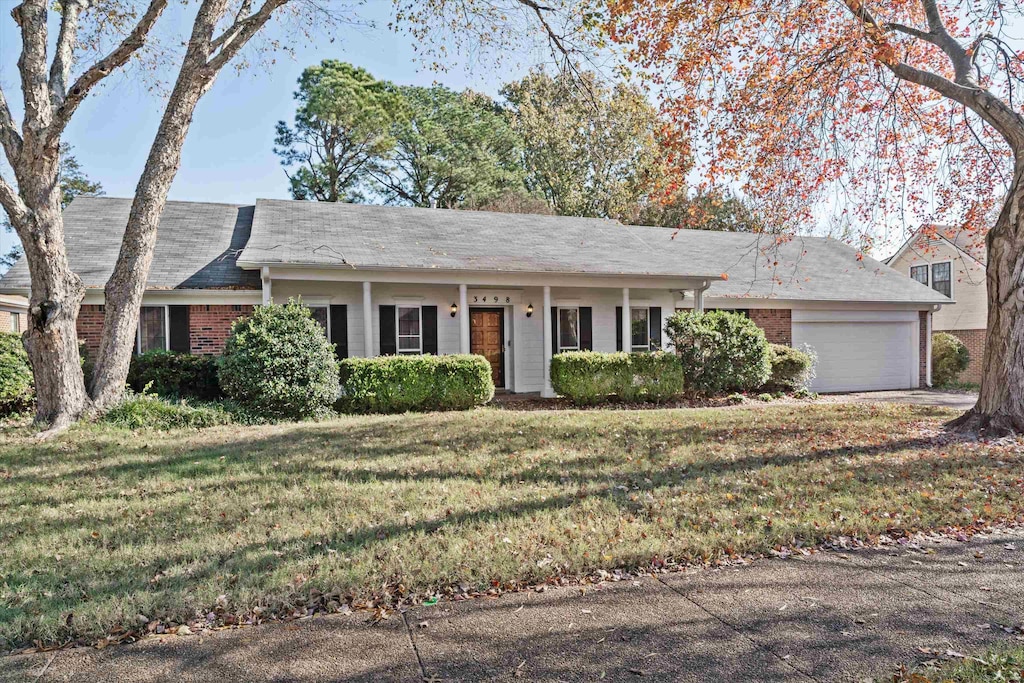 ranch-style home with a garage and a front lawn