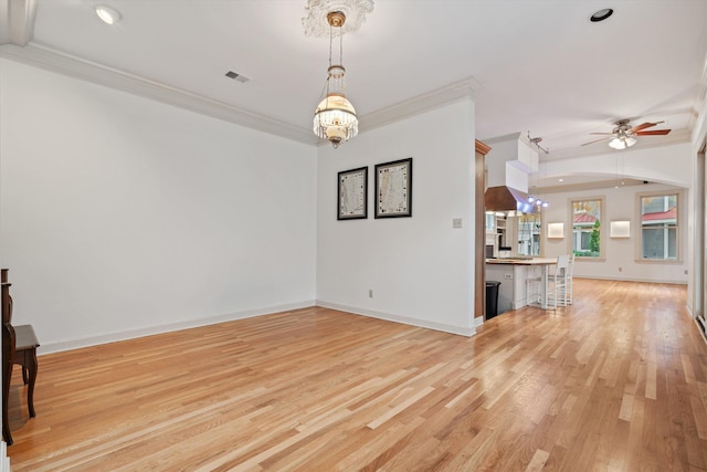 living room with ceiling fan with notable chandelier, light wood-type flooring, and ornamental molding