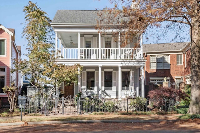 view of front of home with ceiling fan and a balcony