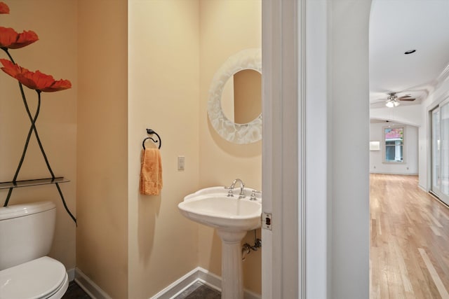 bathroom with hardwood / wood-style flooring, ceiling fan, and toilet