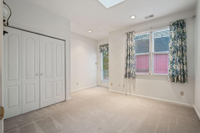 unfurnished bedroom featuring a closet and light colored carpet