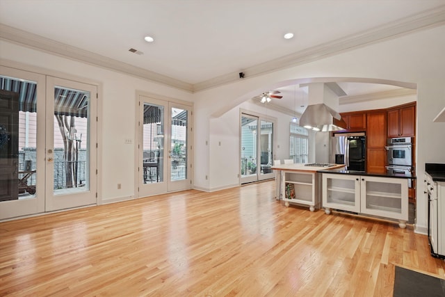 kitchen featuring french doors, appliances with stainless steel finishes, ornamental molding, ceiling fan, and light hardwood / wood-style floors