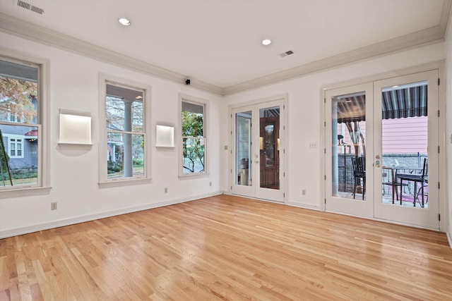 spare room featuring french doors, light wood-type flooring, and ornamental molding