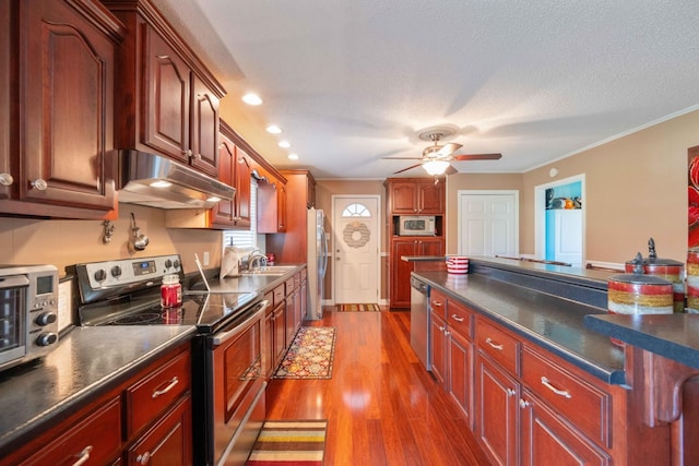 kitchen with ornamental molding, stainless steel appliances, ceiling fan, dark wood-type flooring, and sink