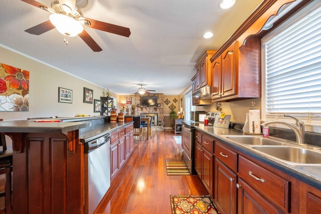 kitchen with a breakfast bar, stainless steel appliances, crown molding, sink, and dark hardwood / wood-style floors