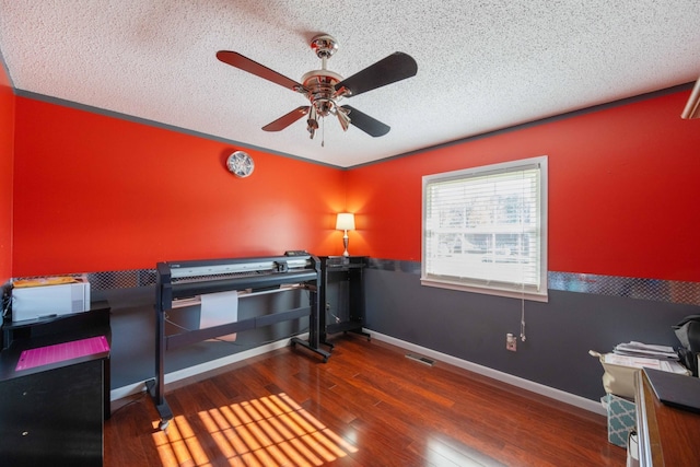 bedroom with dark hardwood / wood-style floors, ceiling fan, and a textured ceiling