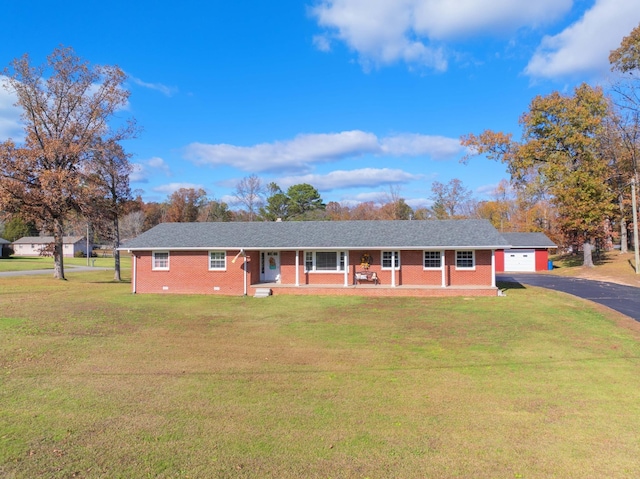 ranch-style house featuring covered porch, a garage, and a front lawn