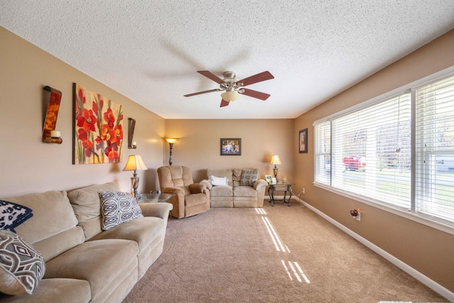 living room featuring carpet flooring, ceiling fan, and a textured ceiling