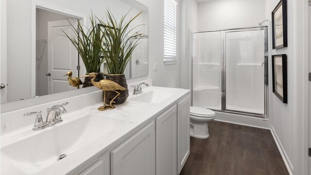 bathroom with vanity, toilet, wood-type flooring, and a shower with shower door