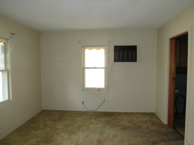 spare room featuring carpet flooring, plenty of natural light, and a wall unit AC