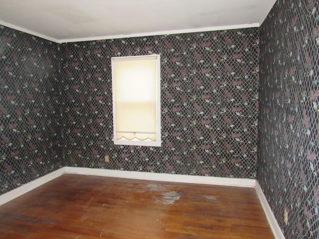 spare room with crown molding, dark wood-type flooring, and tile walls