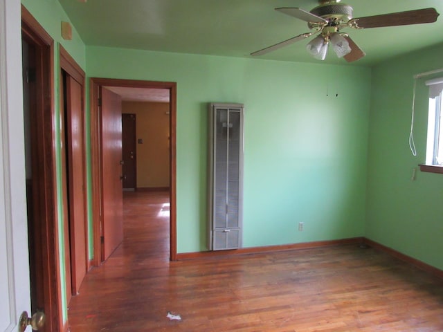 empty room featuring ceiling fan and dark hardwood / wood-style flooring