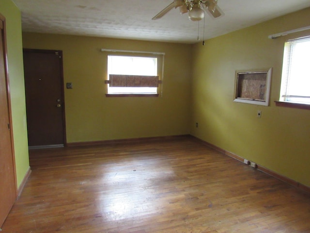 unfurnished room with ceiling fan, a wealth of natural light, and light hardwood / wood-style flooring