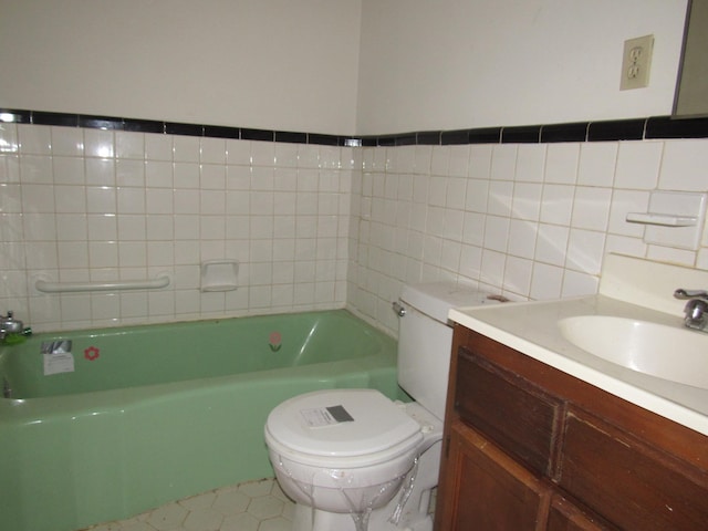 bathroom with a tub, tile patterned flooring, toilet, vanity, and tile walls