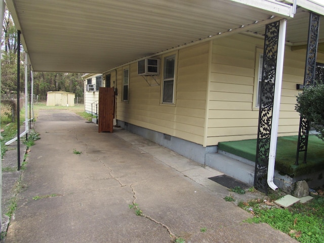 view of patio / terrace with a carport and a shed