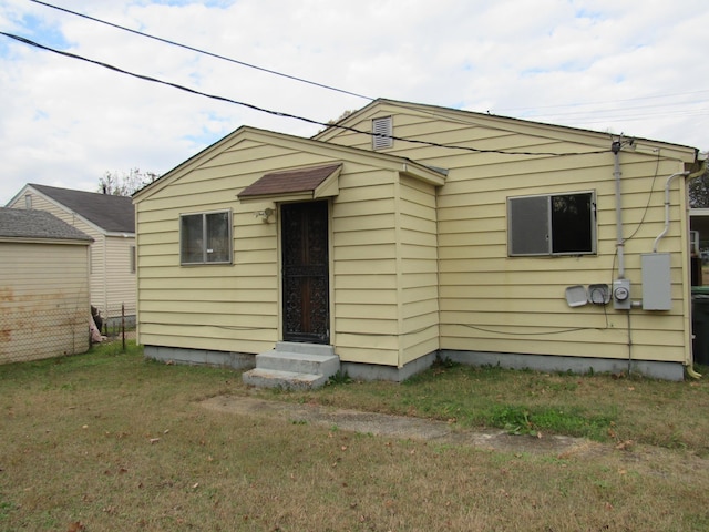 rear view of house featuring a lawn