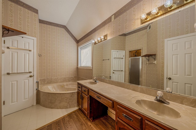 bathroom featuring hardwood / wood-style floors, vanity, shower with separate bathtub, and vaulted ceiling