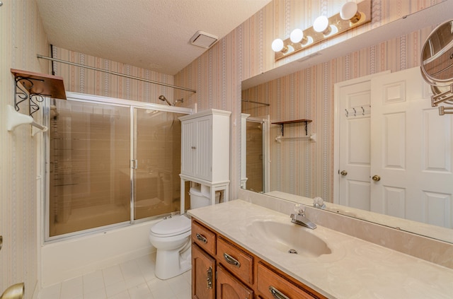 full bathroom with combined bath / shower with glass door, tile patterned floors, a textured ceiling, vanity, and toilet